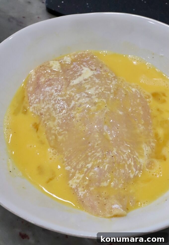 Crispy Parmesan-Crusted Chicken Recipe 8 chicken breast in a bowl of whisked eggs