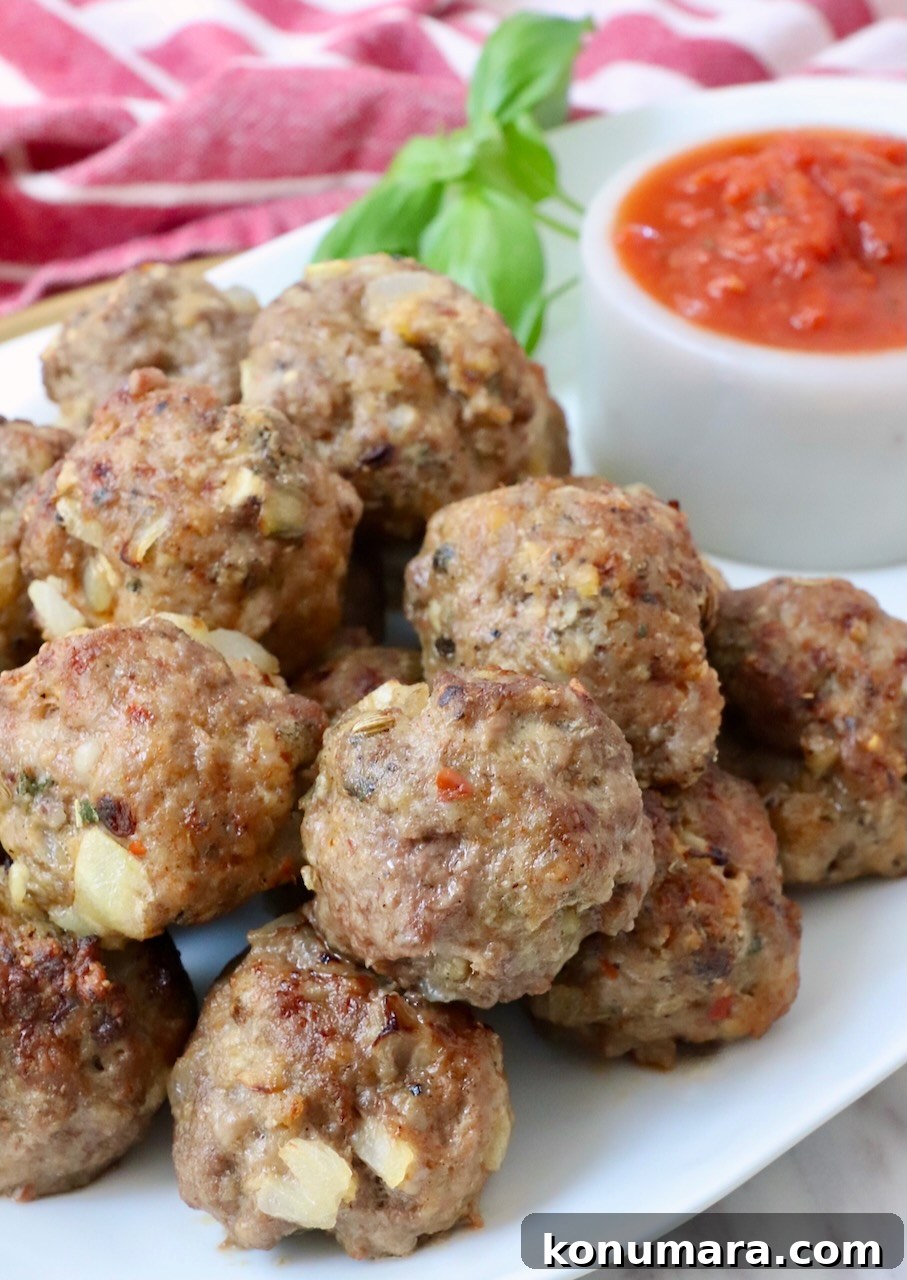Crispy, Juicy Air Fryer Meatballs Recipe 2 meatballs stacked up on a plate