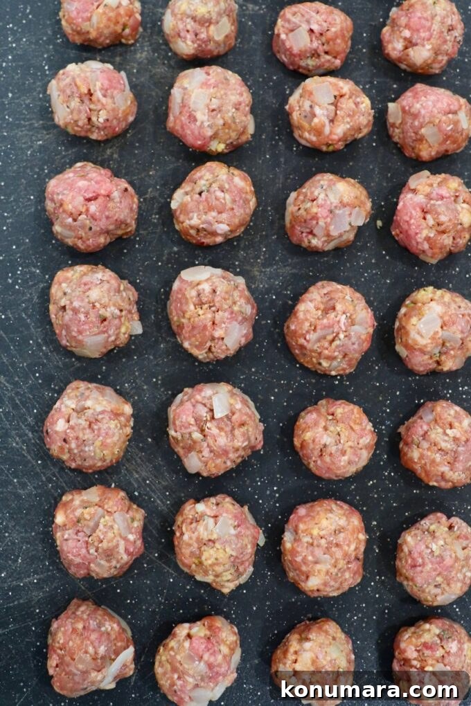 Crispy, Juicy Air Fryer Meatballs Recipe 5 uncooked meatballs on black cutting board