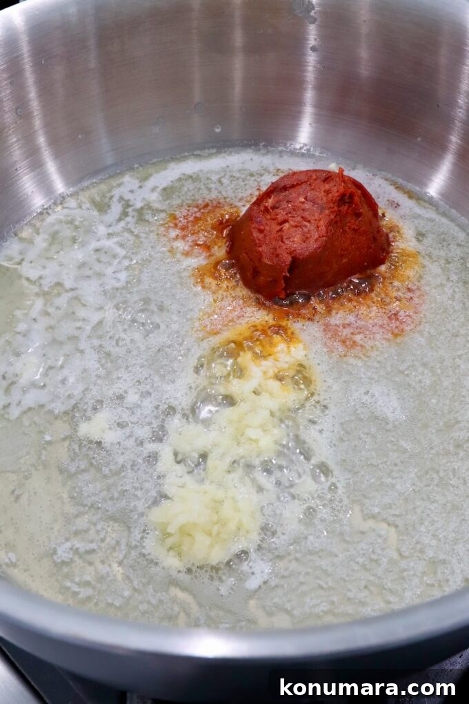 Spicy Nduja Pasta Recipe with Cherry Tomatoes 4 minced garlic and spreadable salami in melted butter in pan