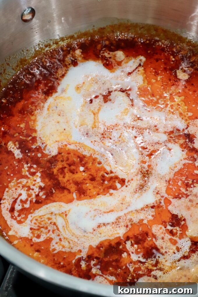 Spicy Nduja Pasta Recipe with Cherry Tomatoes 6 heavy cream in nduja sauce in a pan