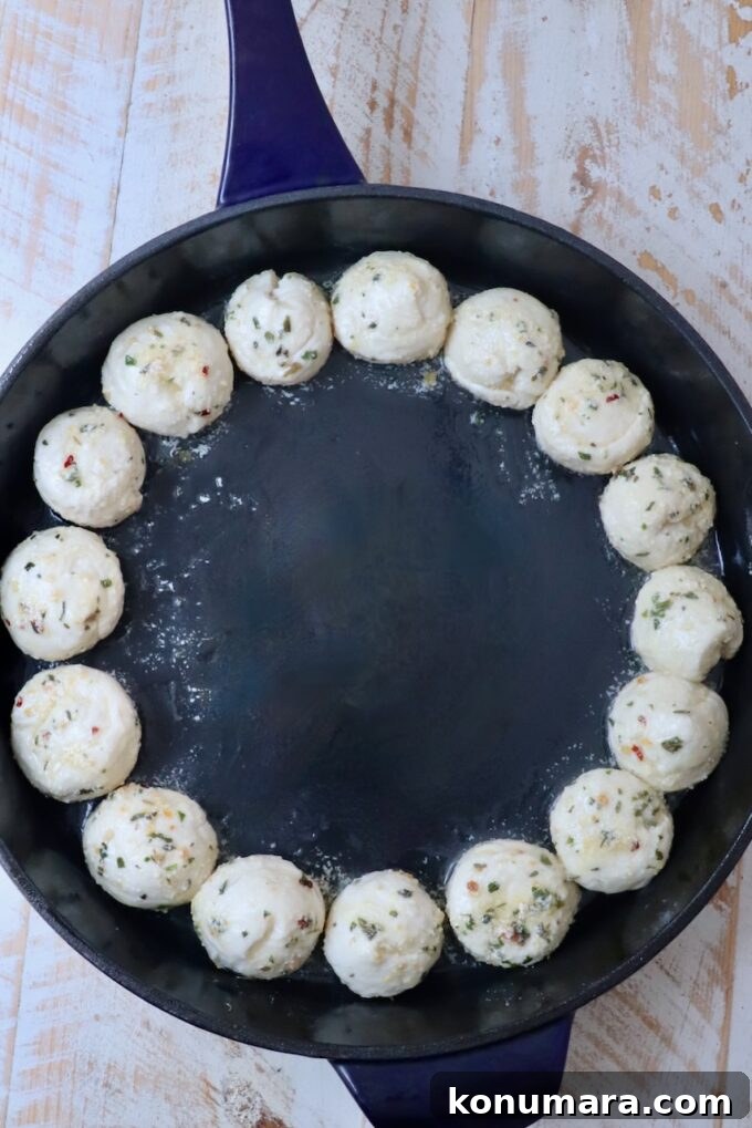 balls of seasoned dough in a cast iron skillet