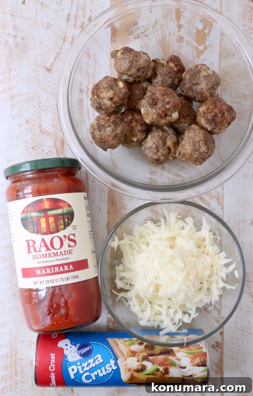 ingredients for meatball sub bites on a white wood board