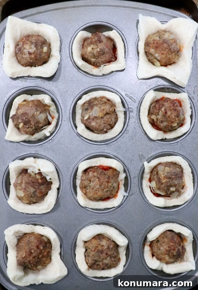 pizza dough squares pressed into a muffin tin and filled with meatballs