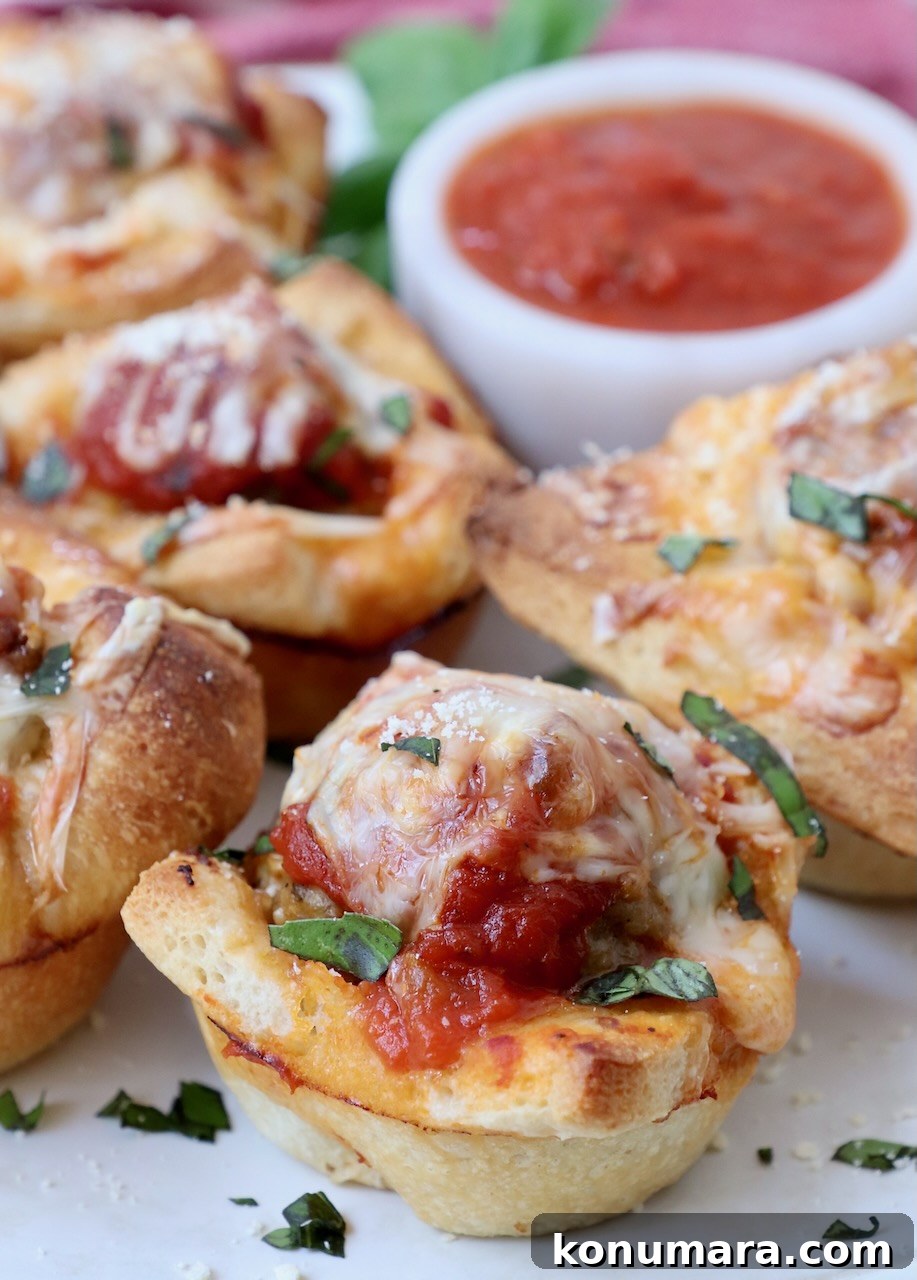 meatball sub bites on a plate with a small bowl of marinara sauce