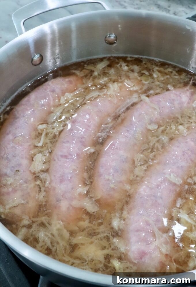 Smoky Grilled Bratwurst with Caramelized Onions 4 bratwurst in pan with beer and sauerkraut