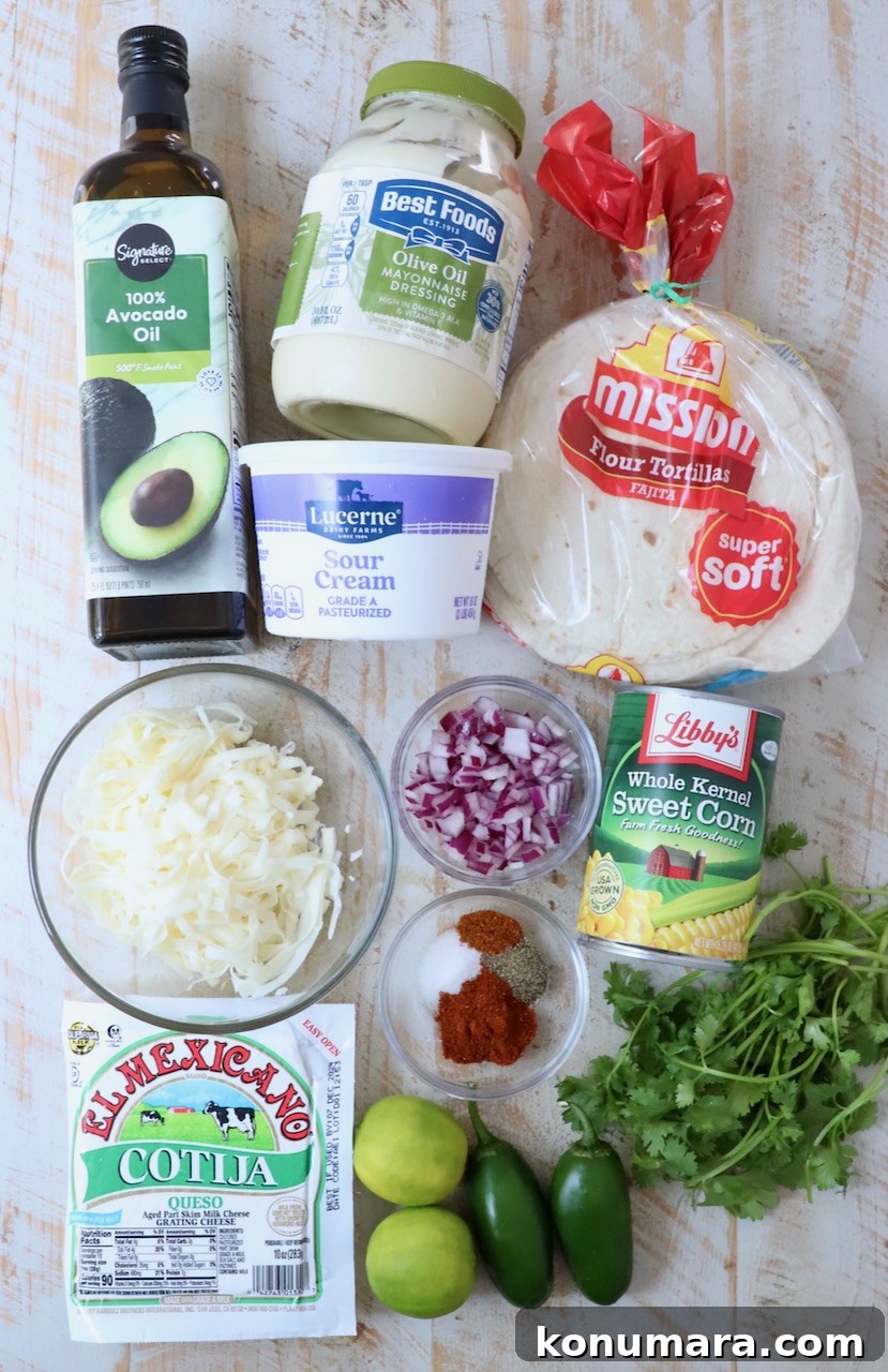 ingredients for Mexican street corn taquitos on a white wood board