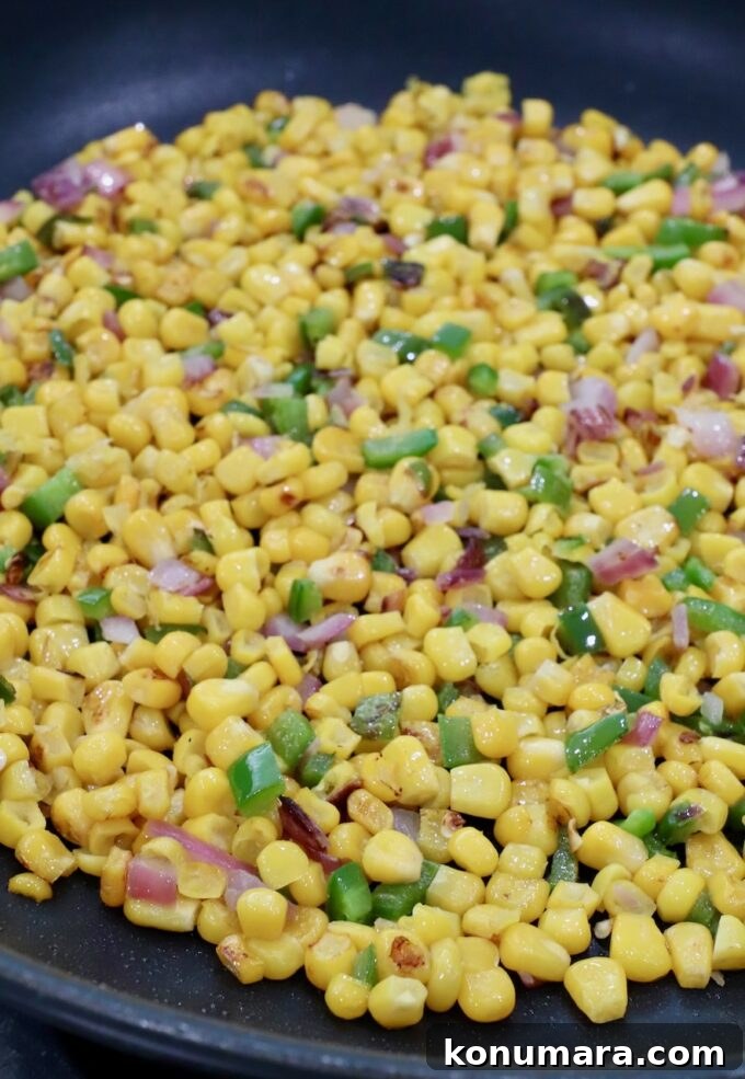 cooked corn kernels, diced onions and jalapenos in a skillet