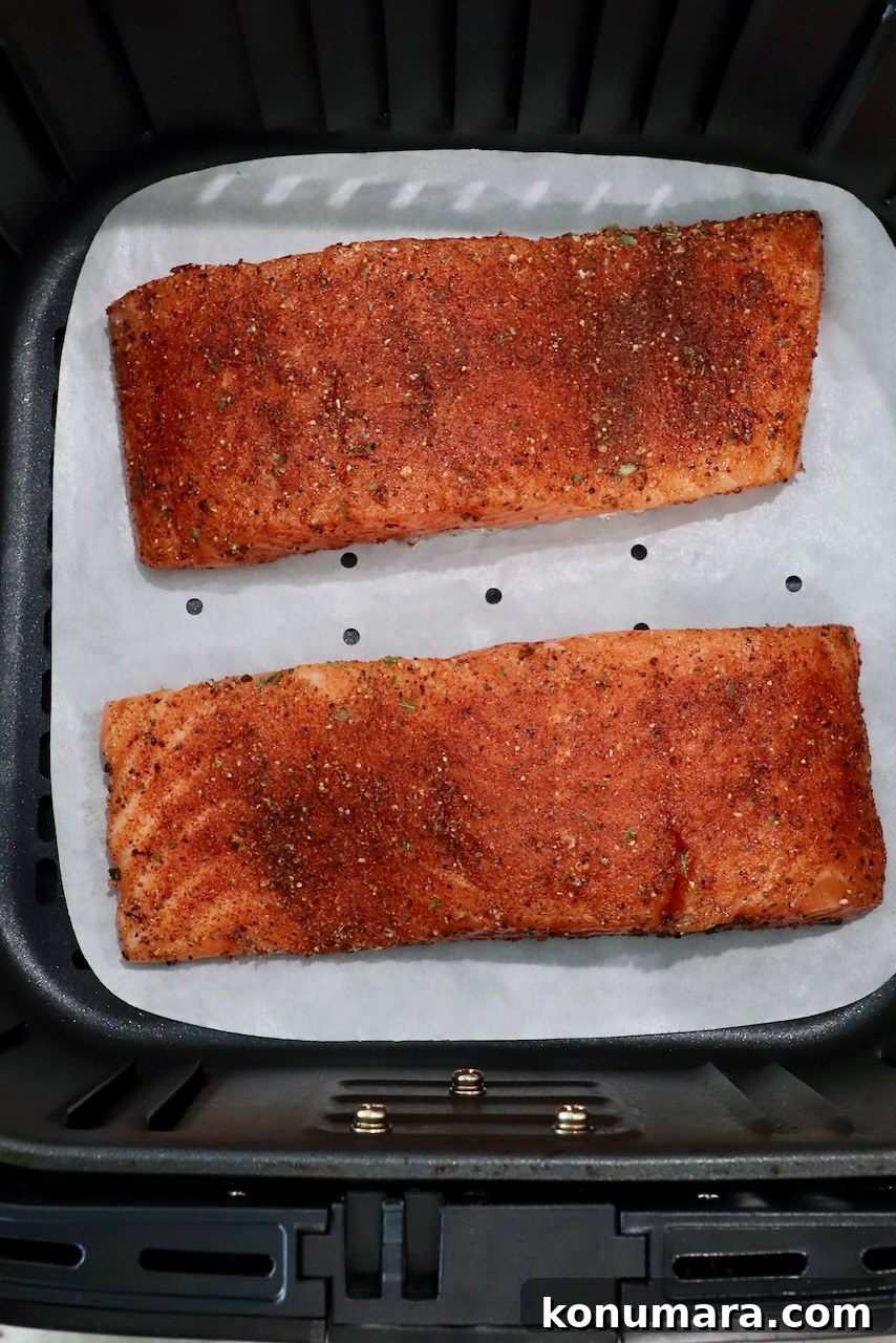 Crispy Air Fryer Salmon with Lemon Garlic Butter 4 seasoned salmon filets in an air fryer basket