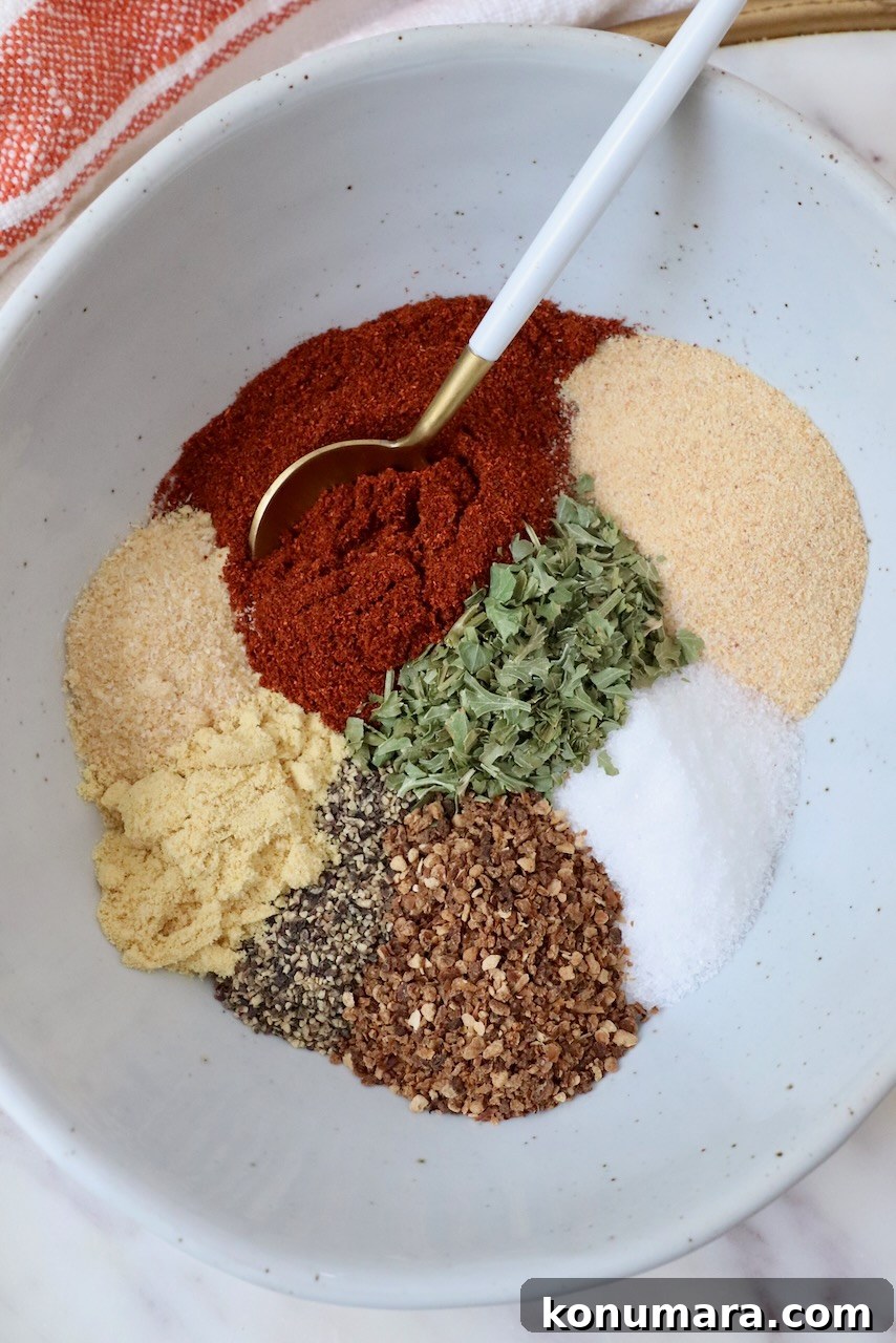Citrus-Herb Salmon Seasoning for Grilling and Baking 6 spices and herbs separated in a bowl with a spoon