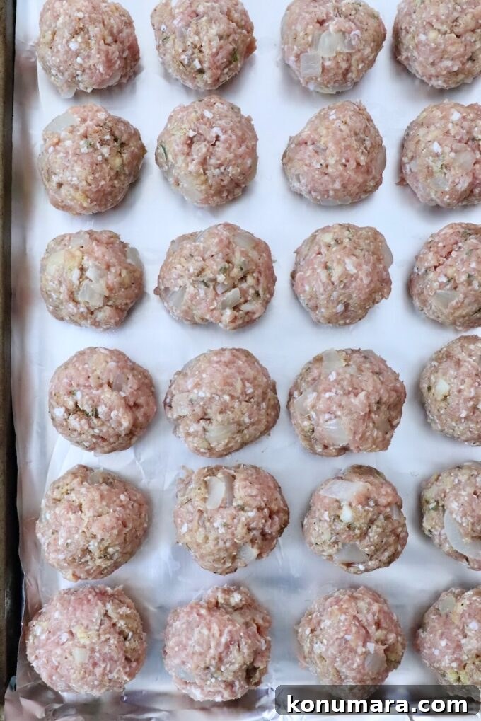 uncooked turkey meatballs on a foil lined baking sheet