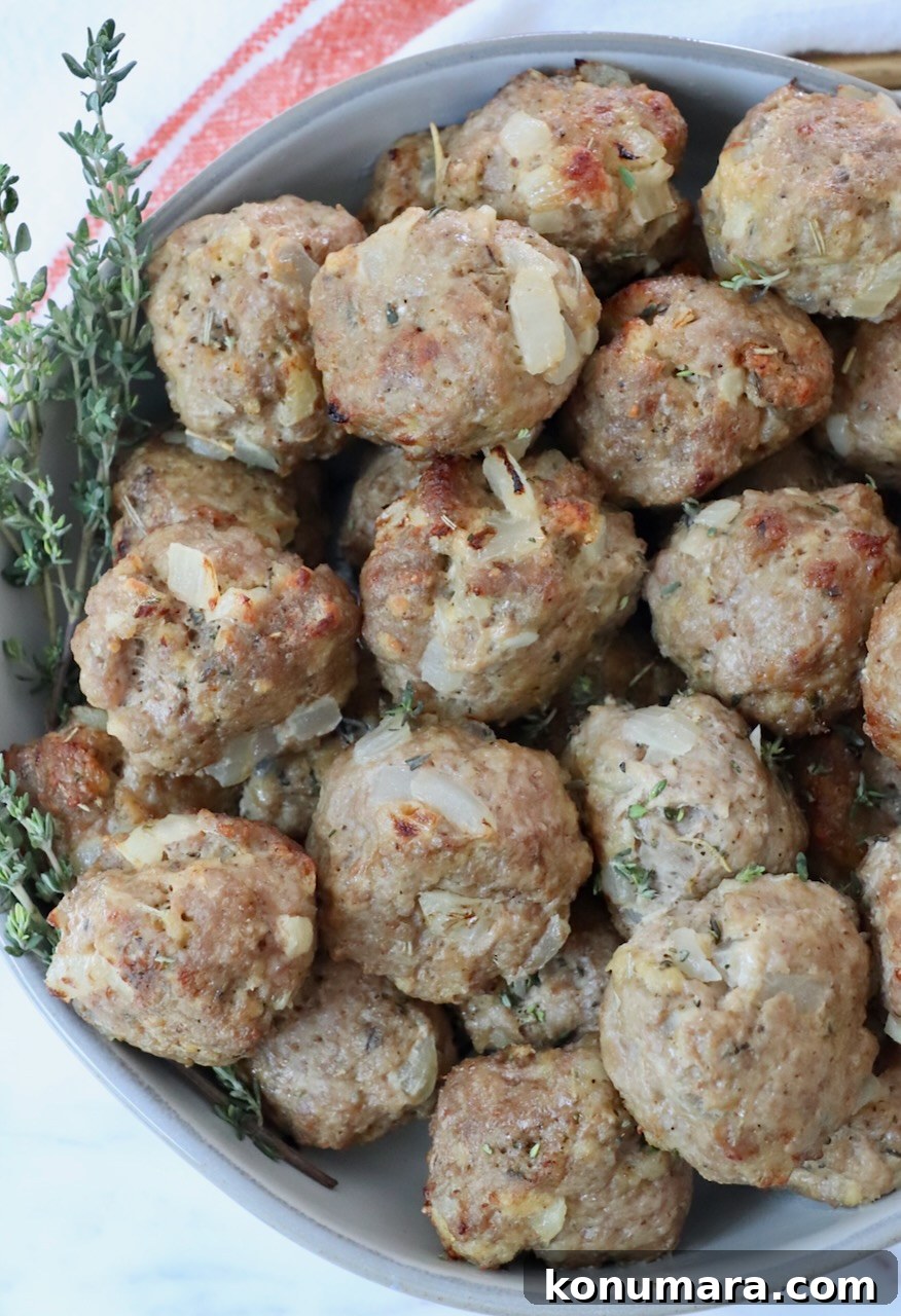 turkey meatballs stacked up in a bowl with fresh thyme