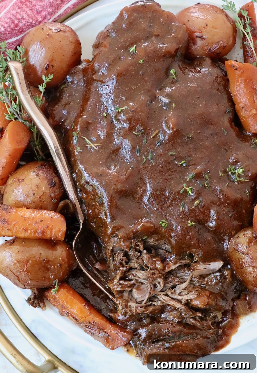 cooked pot roast on plate with fork and vegetables