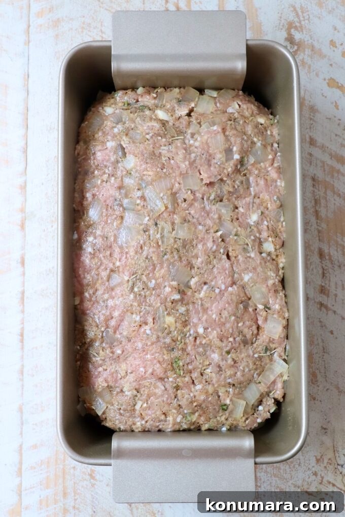 uncooked meatloaf pressed into a loaf pan