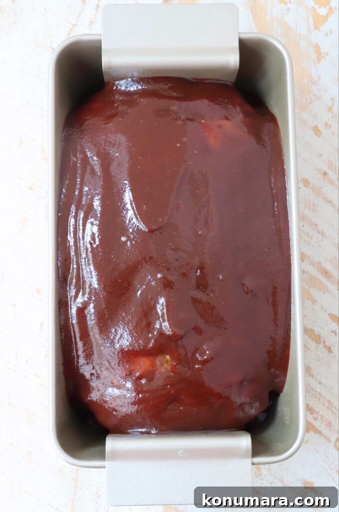 meatloaf topped with bbq sauce in a loaf pan