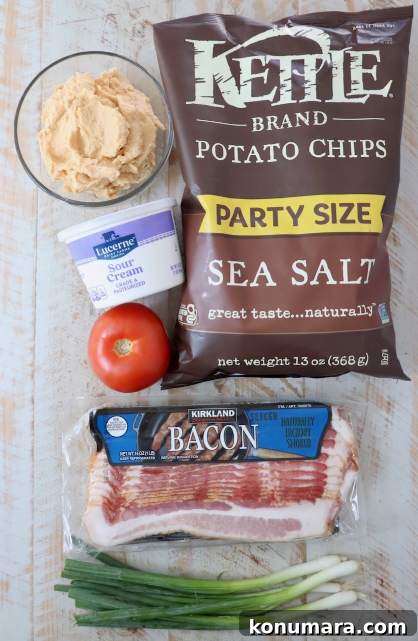 Loaded Irish Nachos with Cheddar, Bacon and Green Onion 3 ingredients for Irish nachos on a white wood board