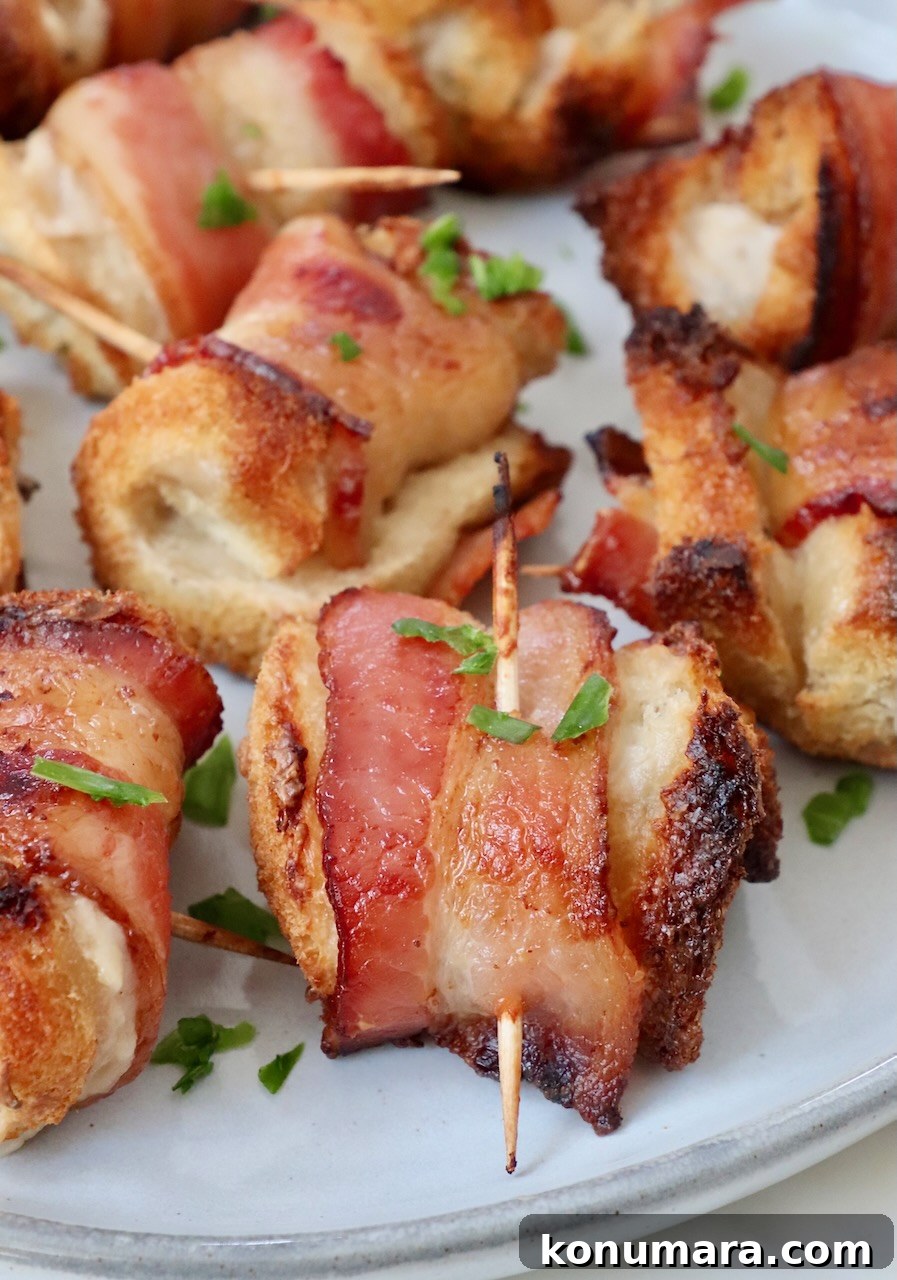 Crispy Bacon Roll Ups with Cream Cheese and Chives 2 bacon roll-ups on a plate garnished with chopped parsley