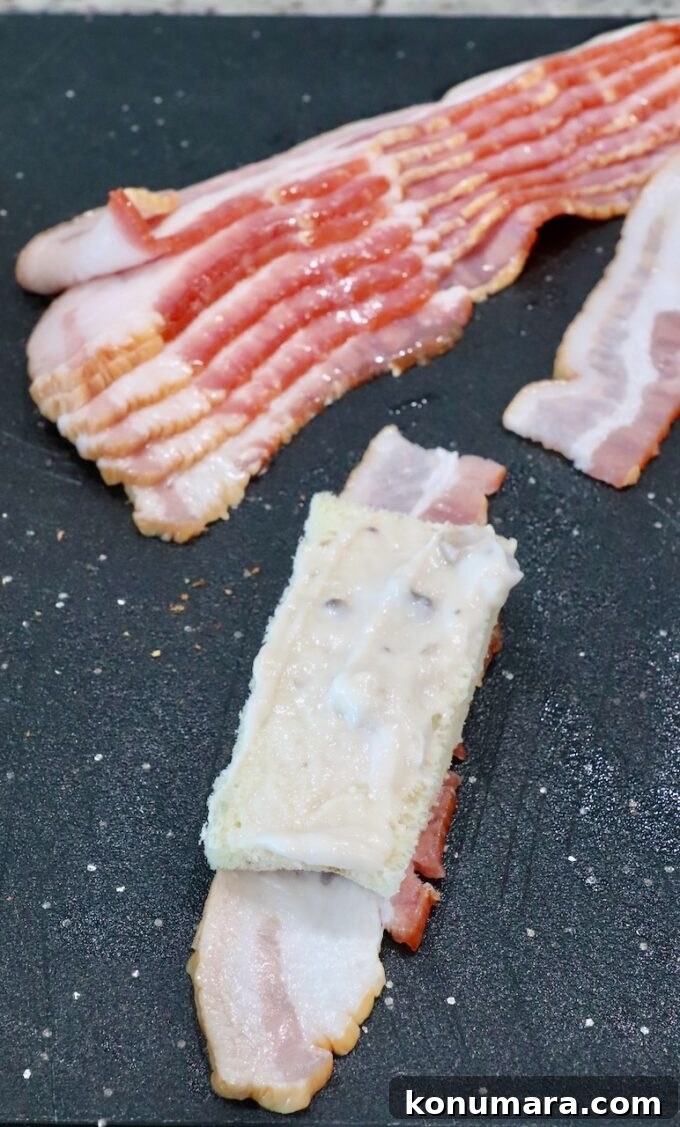 Crispy Bacon Roll Ups with Cream Cheese and Chives 5 slice of white bread coated in cream of mushroom soup on a slice of bacon