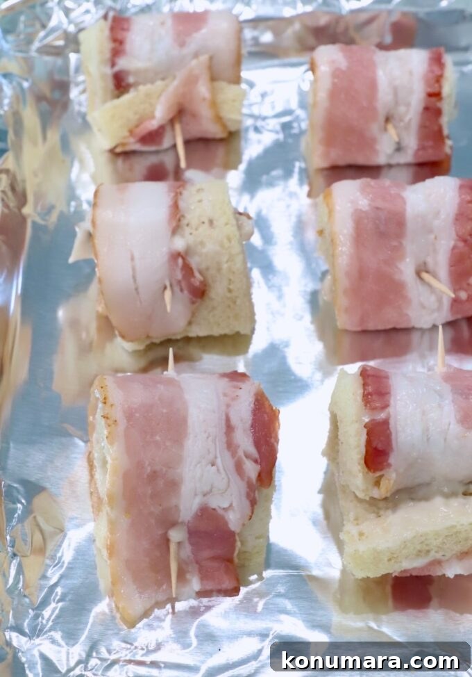 Crispy Bacon Roll Ups with Cream Cheese and Chives 7 bacon roll ups on a foil lined baking sheet