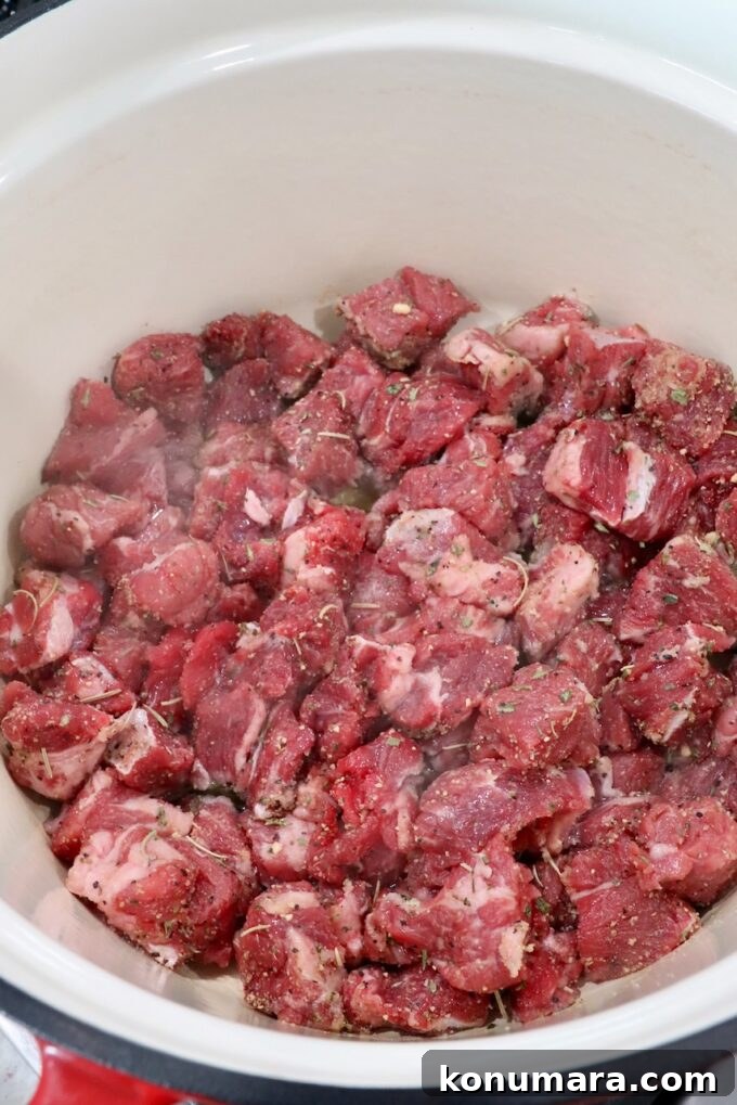 cubes of raw beef chuck roast in a cast iron dutch oven