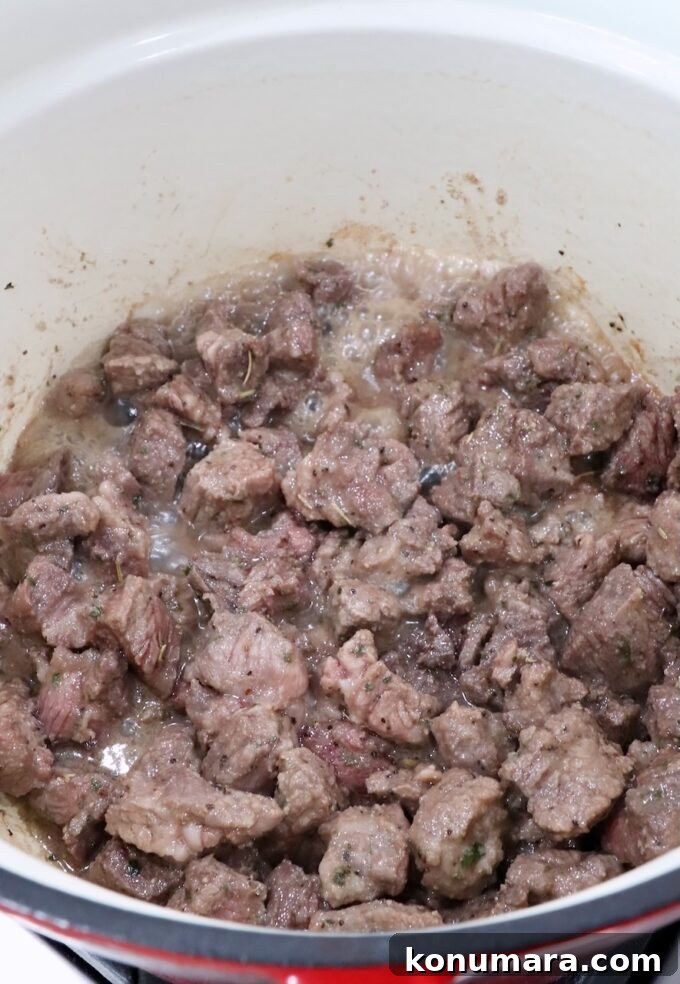 cubes of browned beef chuck roast in a cast iron dutch oven