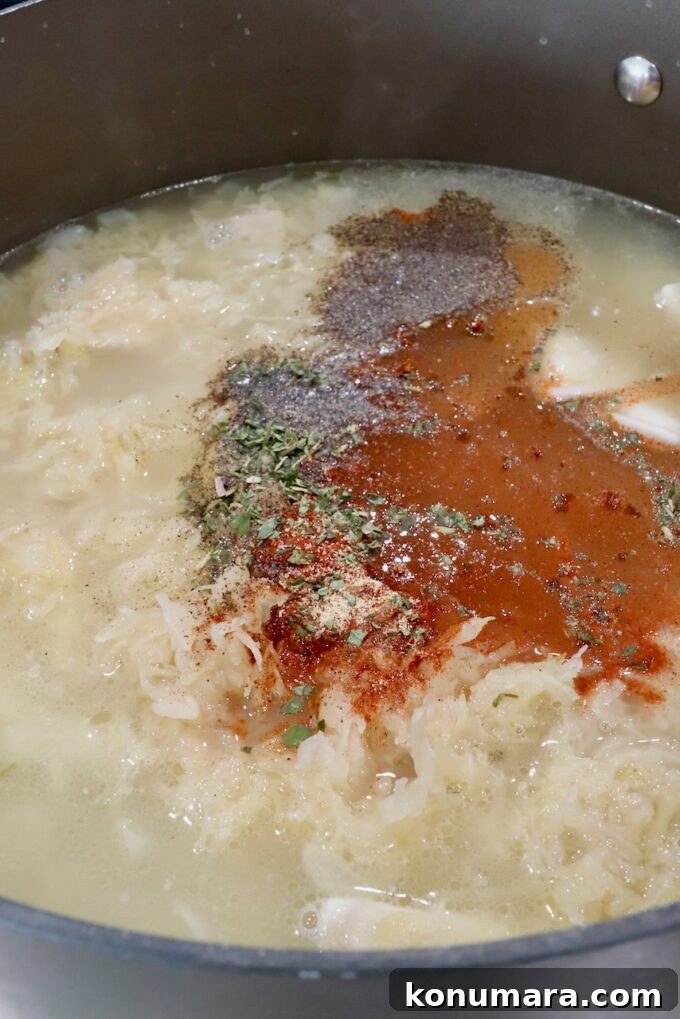 seasonings in a large pot of chicken broth and sauerkraut