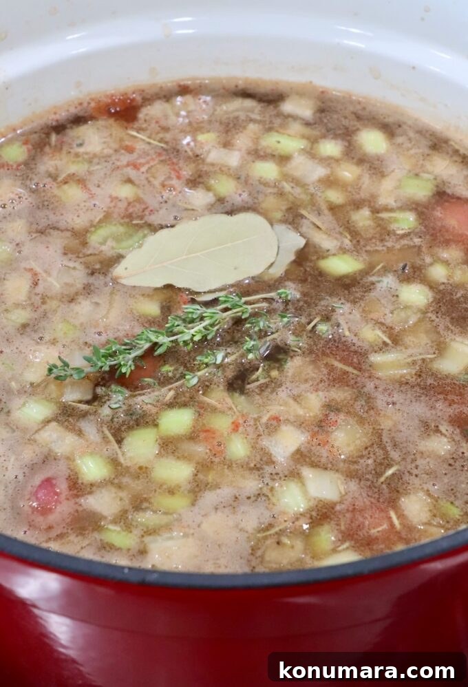 Comforting Slow-Cooked Beef Stew Recipe 8 beef stew in a large dutch oven topped with bay leaves and thyme sprigs