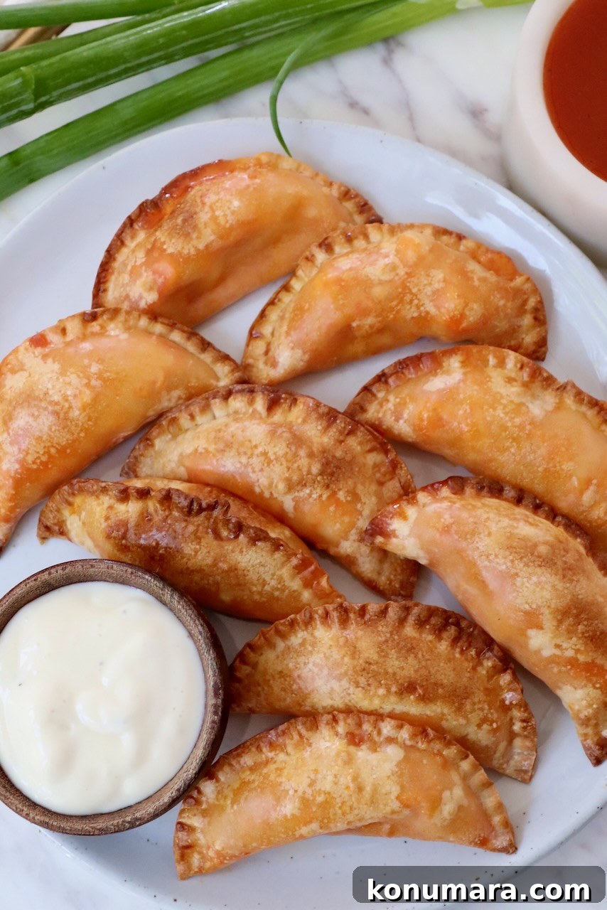 Crispy Buffalo Chicken Bites Recipe with Blue Cheese Dip 10 buffalo chicken bites on a plate with a small bowl of blue cheese dressing