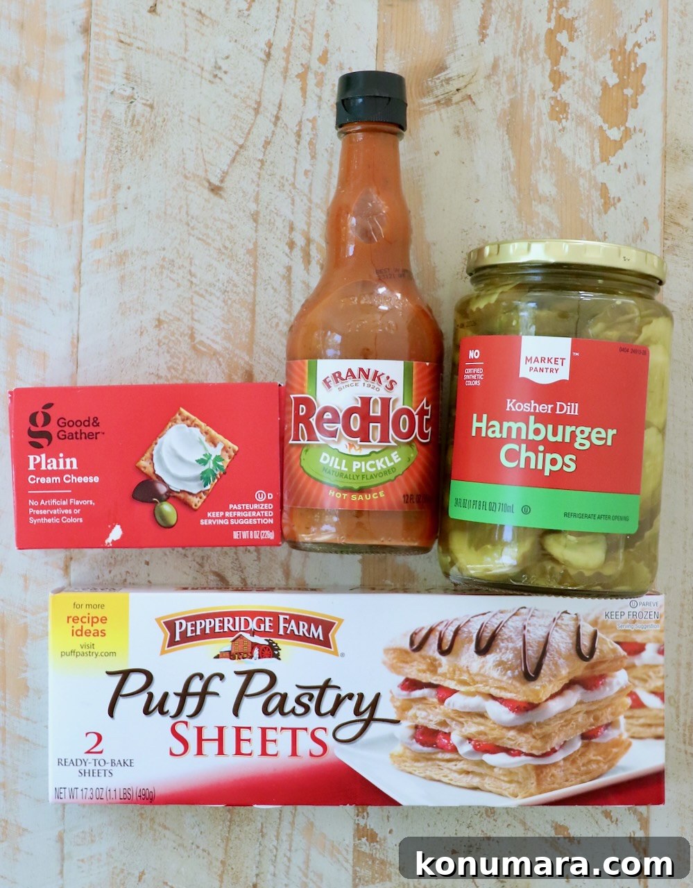 Crispy Puff Pastry Pickle Bites Recipe 3 ingredients for puff pastry pickle bites on a white wood board