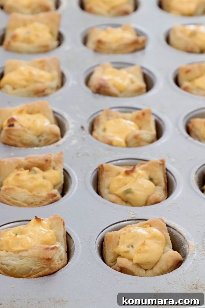 Crispy Puff Pastry Pickle Bites Recipe 5 baked puff pastry dough in a mini muffin tin filled with a cream cheese filling