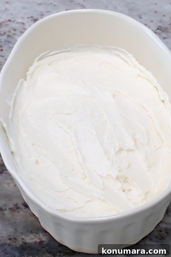 Cream cheese filling spread in the bottom of a casserole dish