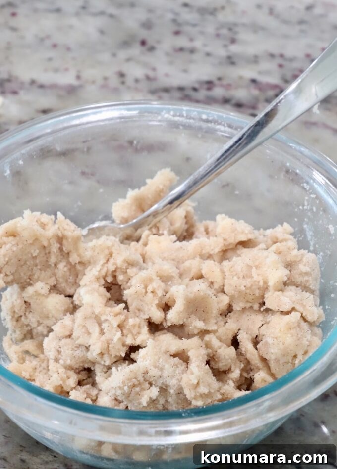 Cinnamon sugar crumble in a glass bowl with a fork