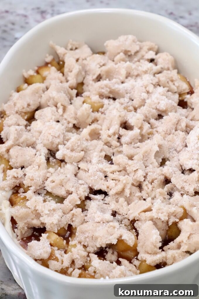 Cinnamon sugar crumble on top of apple pie filling in a casserole dish