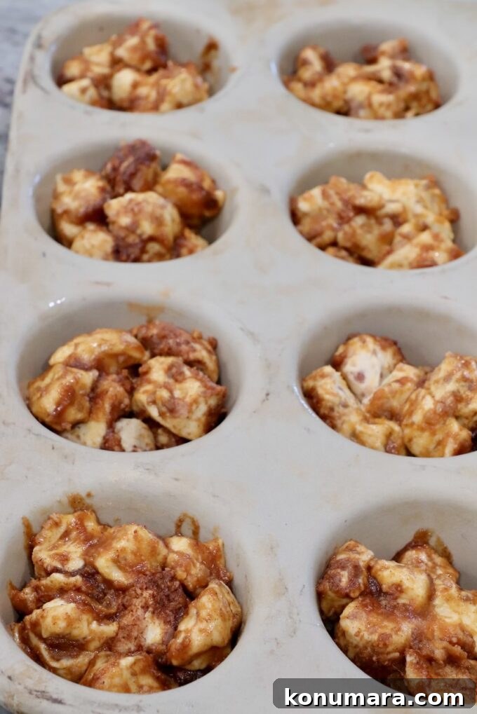 Maple-Glazed Pull-Apart Pumpkin Cinnamon Rolls 8 pieces of pumpkin coated cinnamon rolls divided into a muffin pan