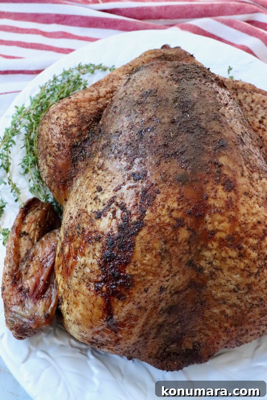 Smoked Turkey Recipe for Thanksgiving: Juicy, Crispy Skin 8 seasoned smoked turkey on a platter with fresh herbs