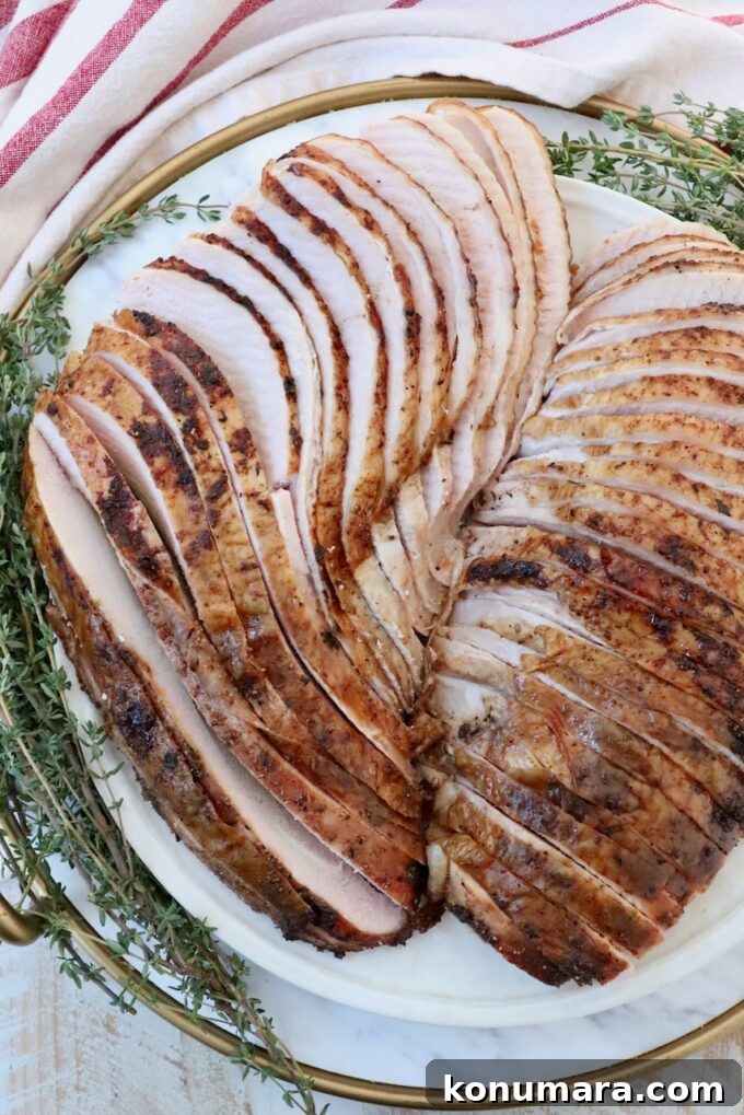 Smoked Turkey Recipe for Thanksgiving: Juicy, Crispy Skin 10 sliced turkey breast on a plate with fresh herbs