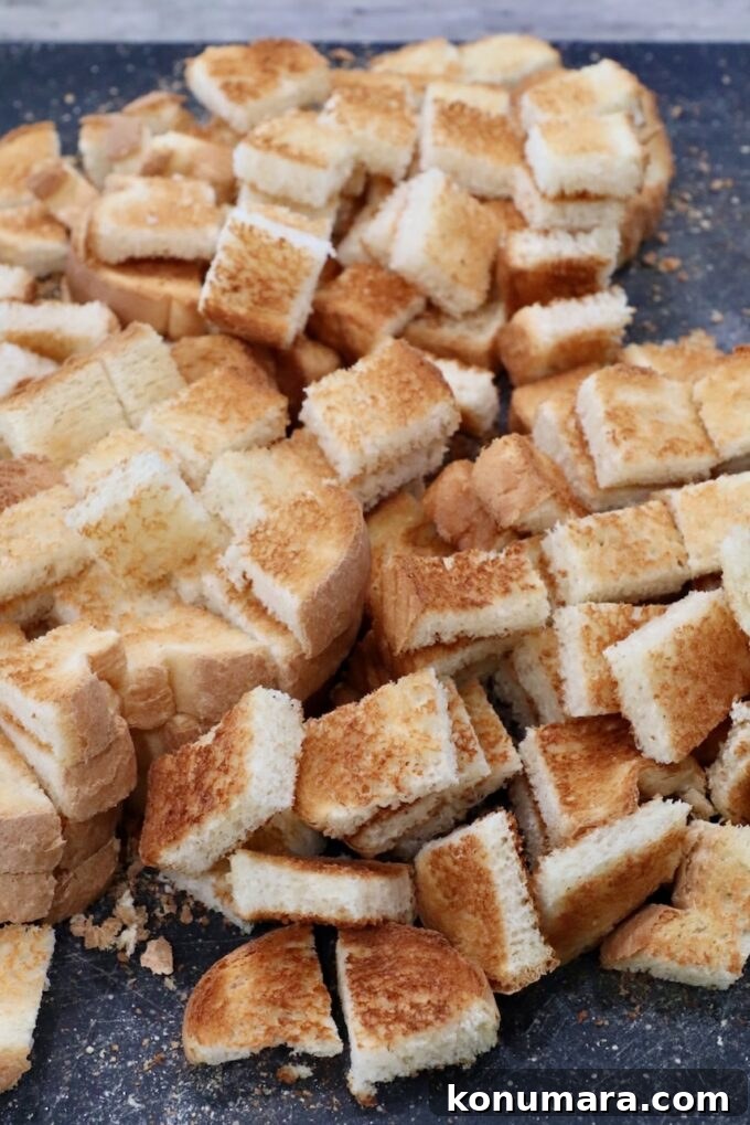 Mushroom Stuffing Recipe with Garlic and Herbs 4 toasted cubes of bread on a cutting board