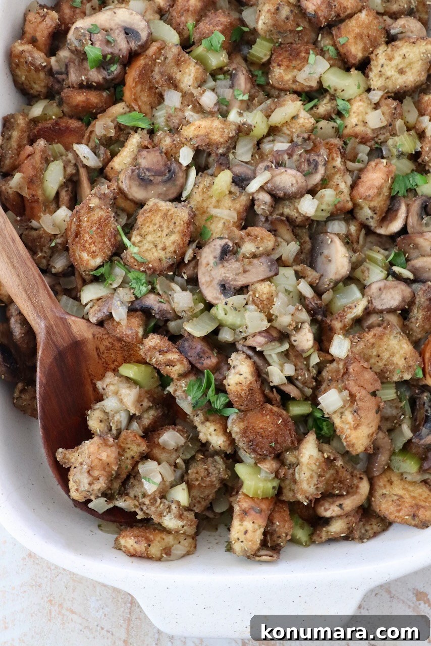 Mushroom Stuffing Recipe with Garlic and Herbs 10 stuffing in a casserole dish with a serving spoon