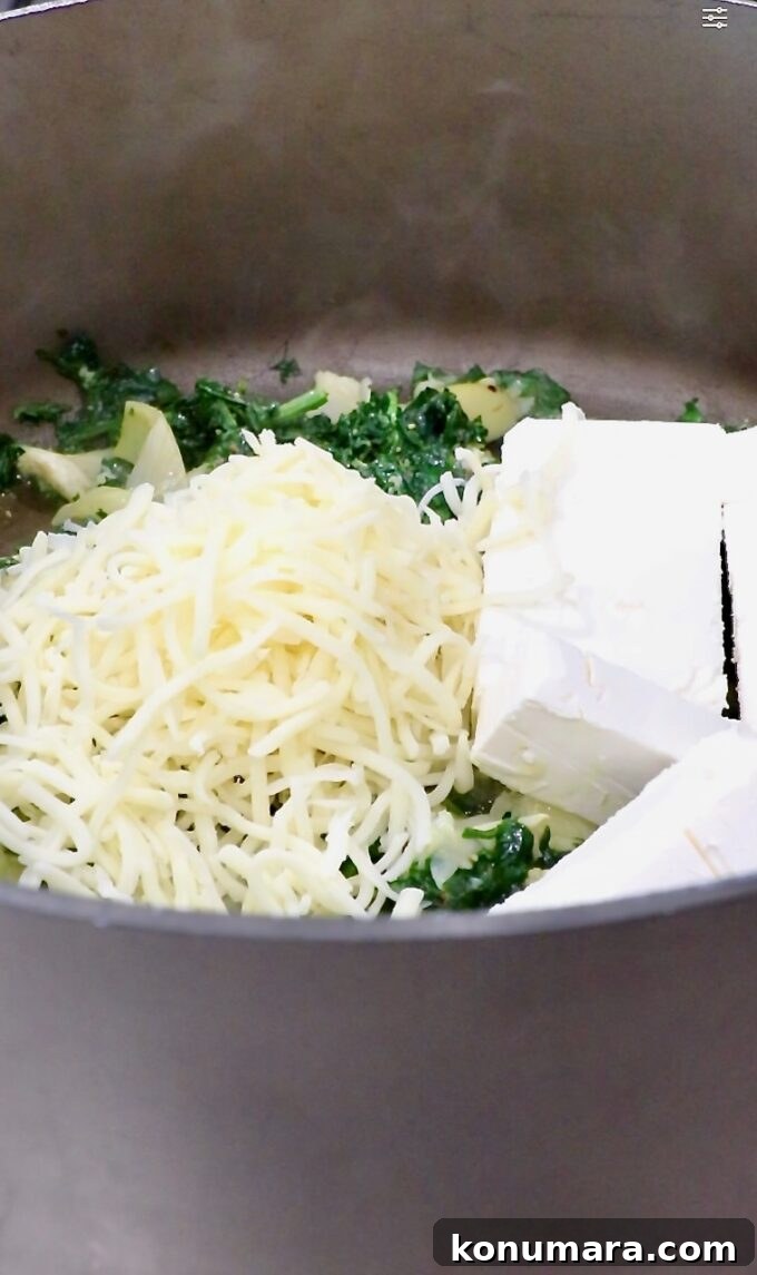 Creamy Baked Spinach and Artichoke Dip Recipe 5 shredded mozzarella cheese and cubed cream cheese in a large pot with spinach