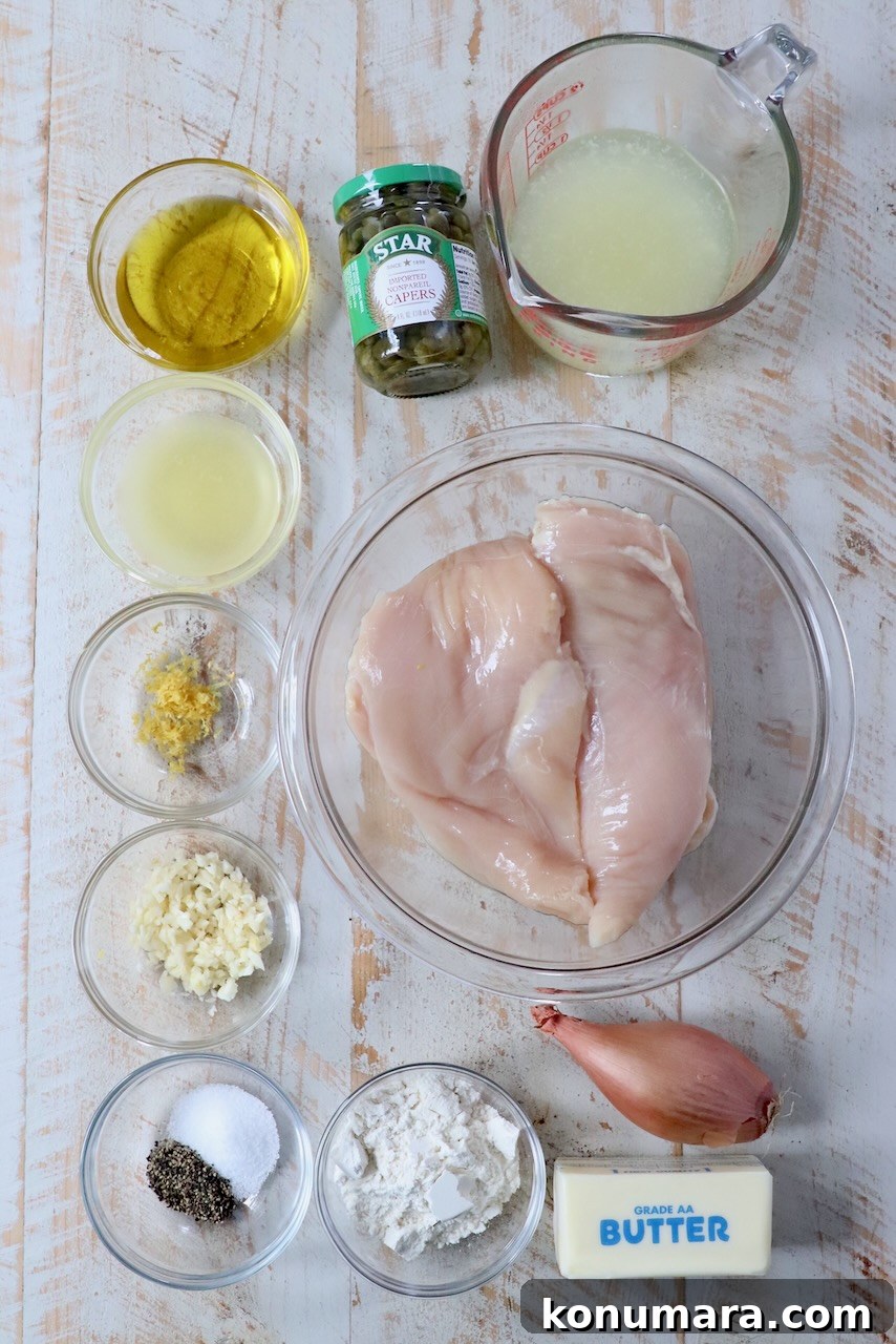 ingredients for chicken piccata on a white wood board