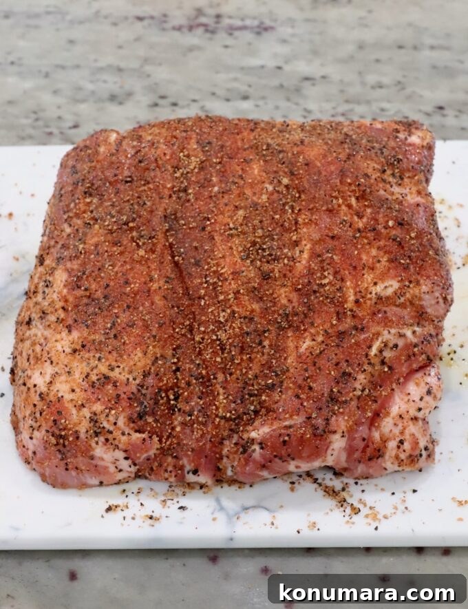 Slow-Cooker BBQ Pulled Pork Recipe 4 seasoned pork shoulder on a cutting board