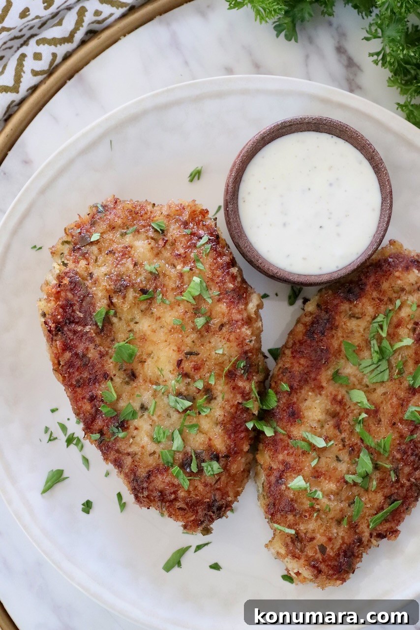 fried breaded pork chops on a plate with a small bowl of ranch dressing