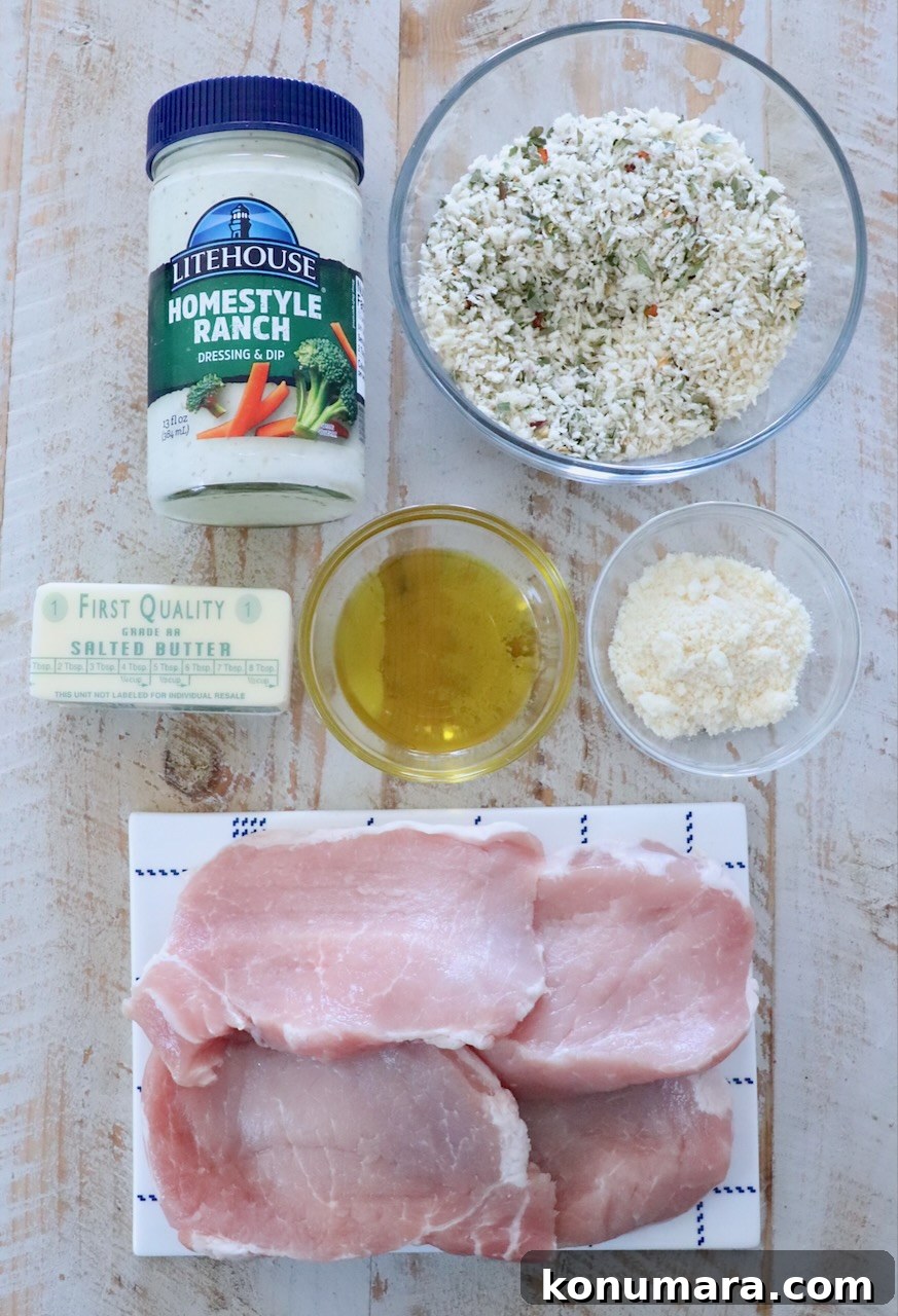 ingredients for breaded pork chops on a white wood board