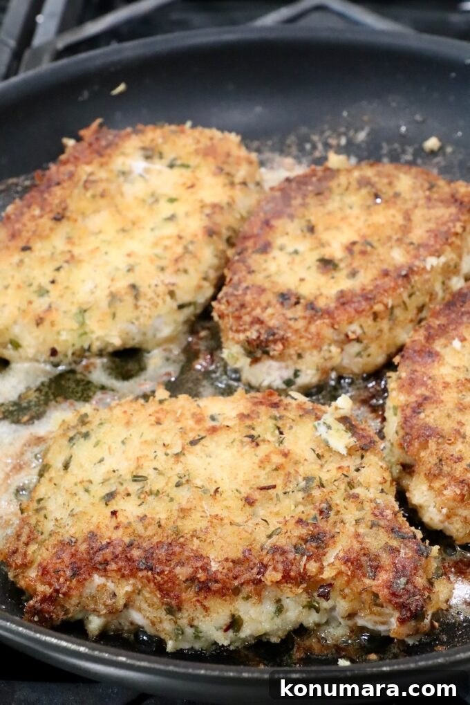 breaded pork chops cooking in a skillet