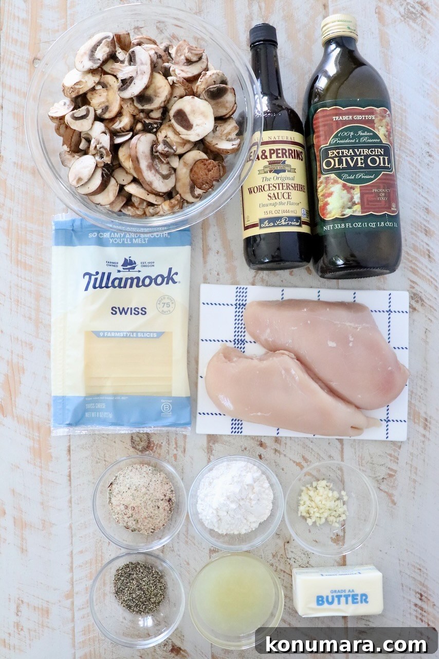 Pan Seared Chicken with Mushrooms and Swiss Cheese 3 ingredients for mushroom chicken on a white wood board