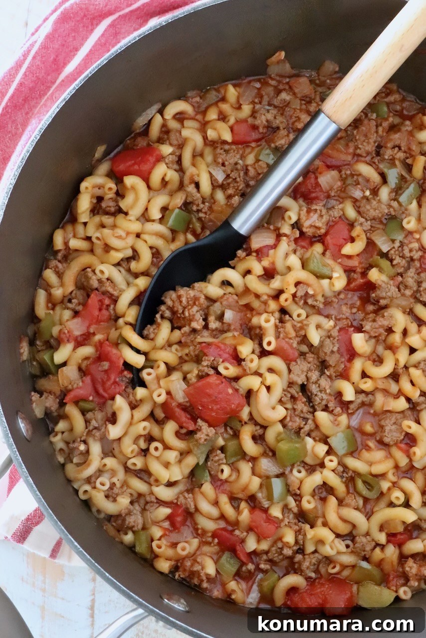 ground beef goulash in a pot with a serving spoon