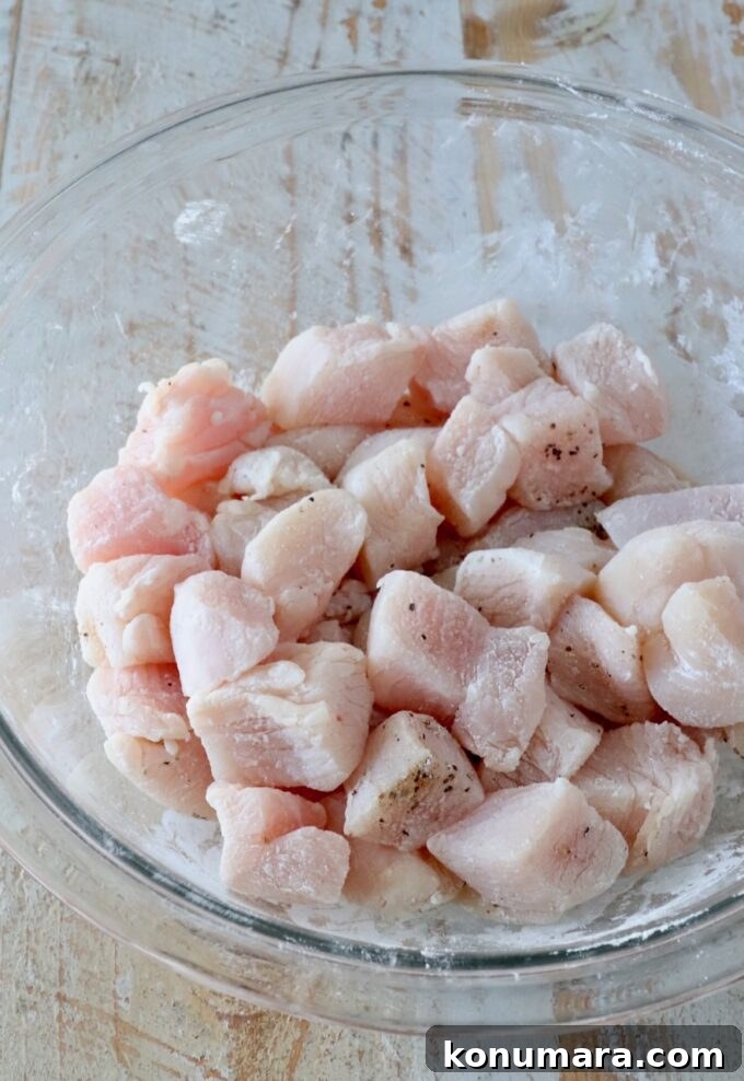 Korean Gochujang Chicken Recipe 5 Chicken pieces tossed in seasoned cornstarch in a glass bowl