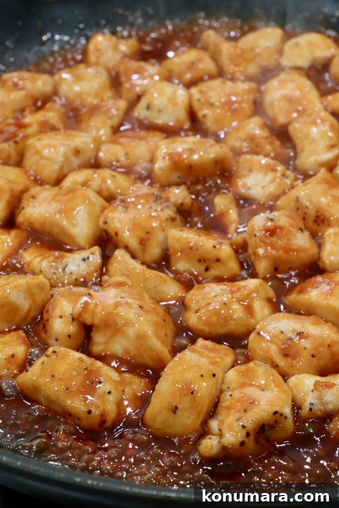 Korean Gochujang Chicken Recipe 7 Chicken pieces coated in gochujang sauce in a skillet