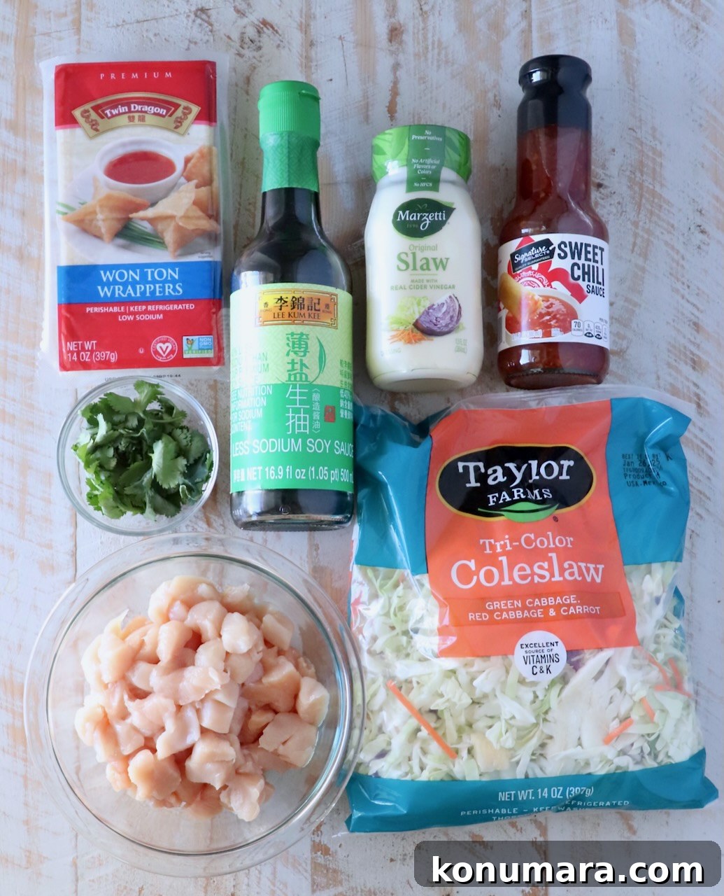 Ingredients for chicken wonton tacos on a white wood board