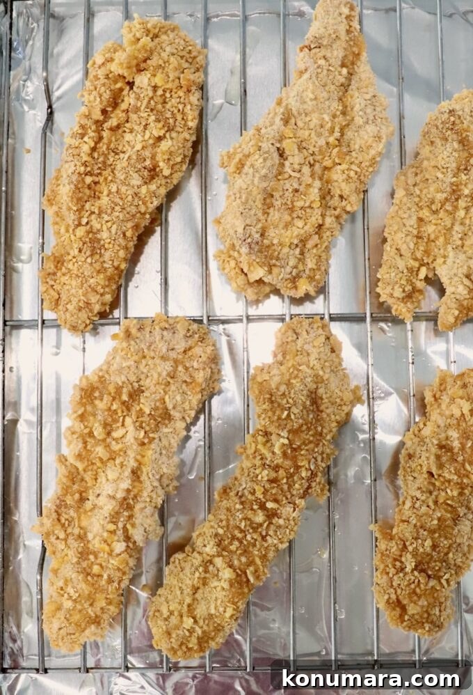 Hot Honey Glazed Chicken Recipe 4 Breaded chicken strips on a wire rack on top of a baking sheet